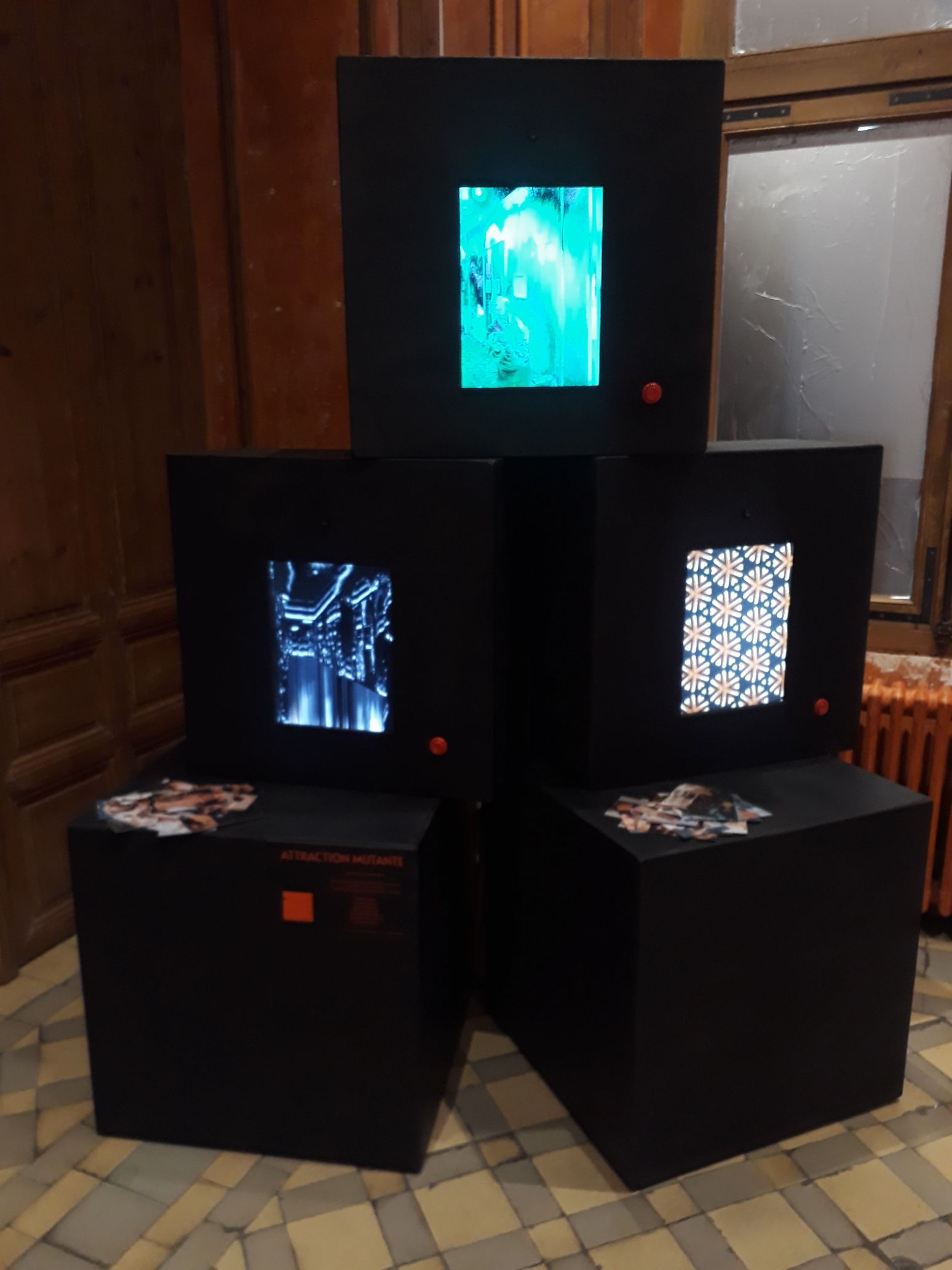 Photo de l'installation attraction mutante : 3 gros cubes noirs en bois avc des écrans intégrés